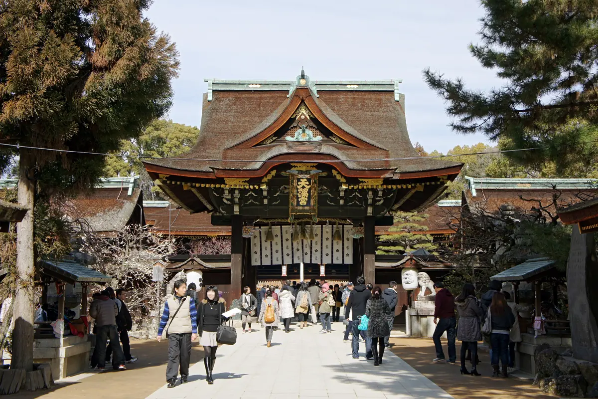 京都北野天满宫的正门，梅花盛开，游客沿参道而上